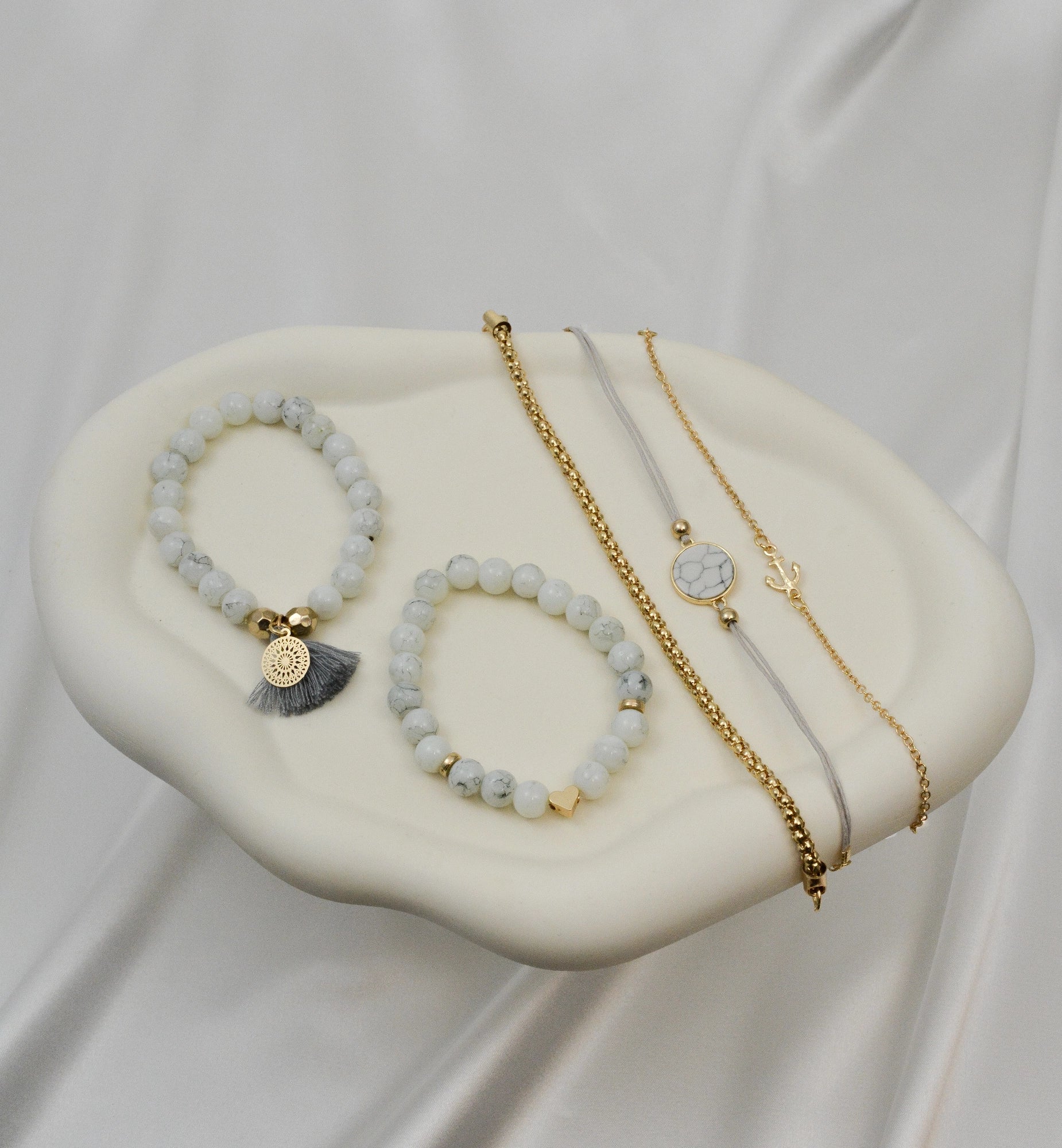 Armband Set Didyma liegend – einzelne weiße, graue und goldfarbene Zugarmbänder