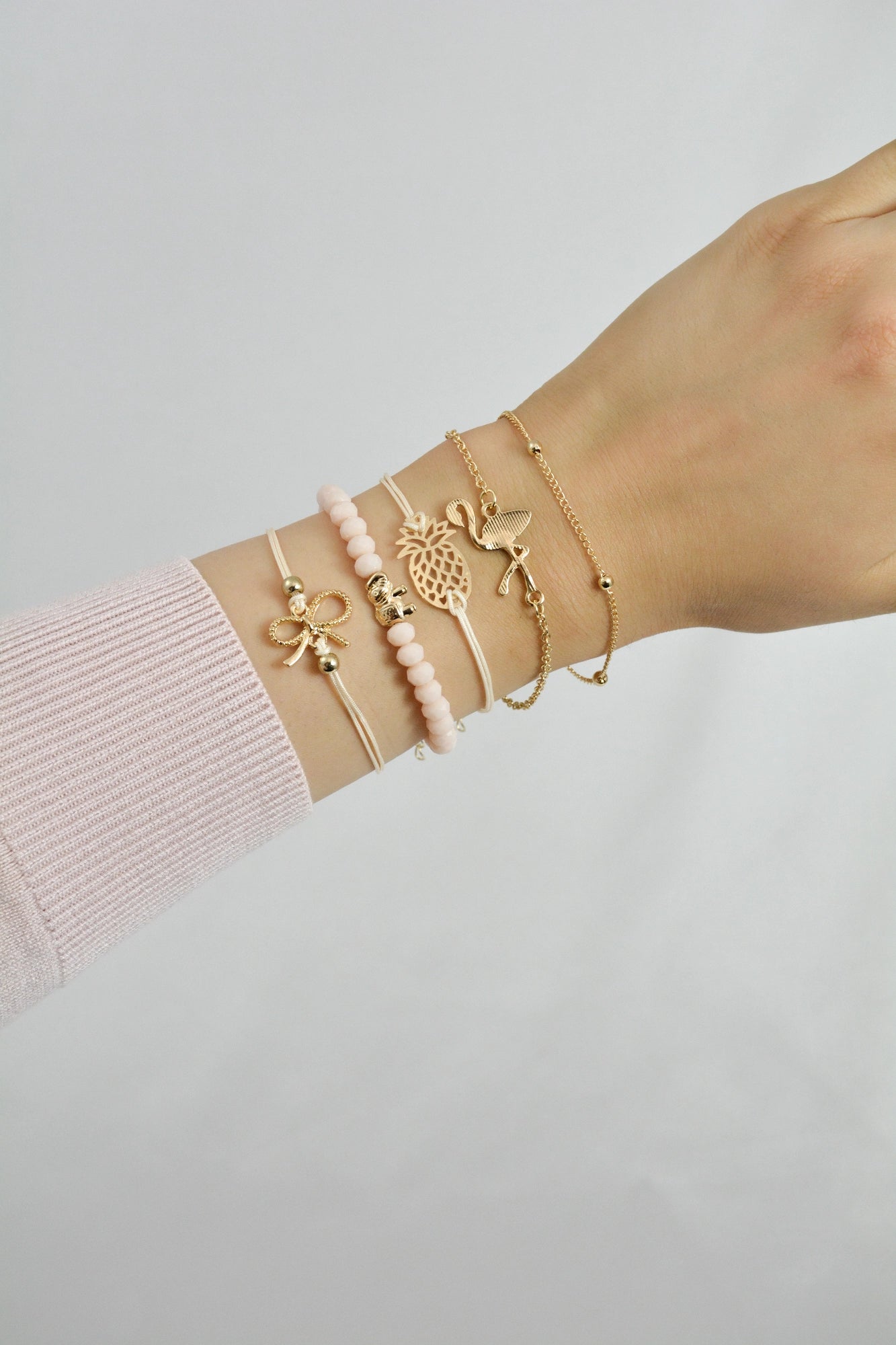 Armband Set Piny getragen am Handgelenk – rosa und goldfarbene Modeschmuck‑Armbänder