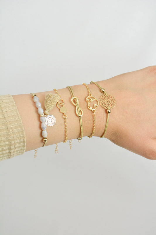 Armband Set Qumy getragen am Handgelenk – sandfarbene und goldfarbene Zugarmbänder Modeschmuck