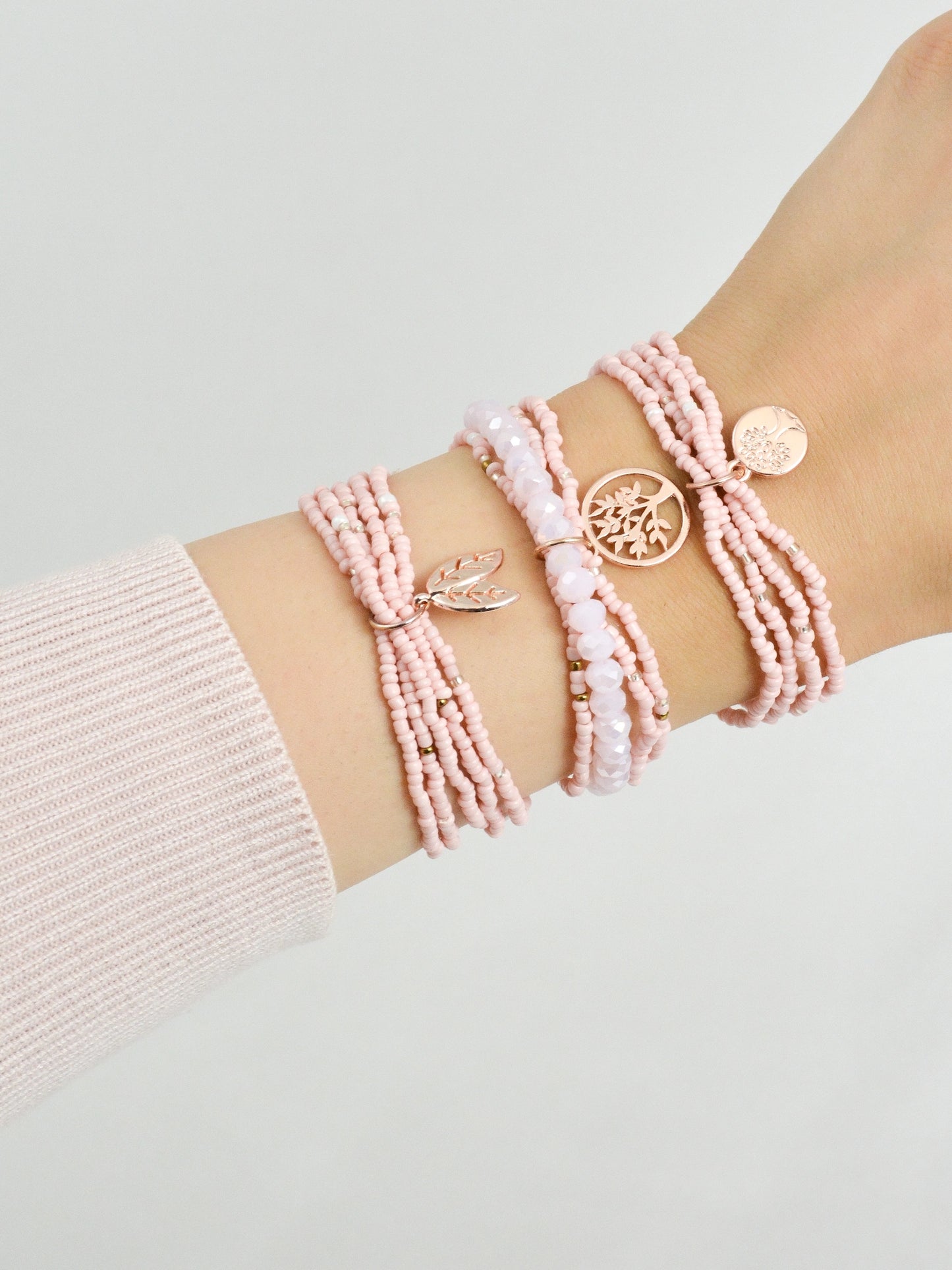 3‑teiliges Armband Set Rosa Fantasy getragen am Handgelenk – rosa und rosegold Modeschmuck