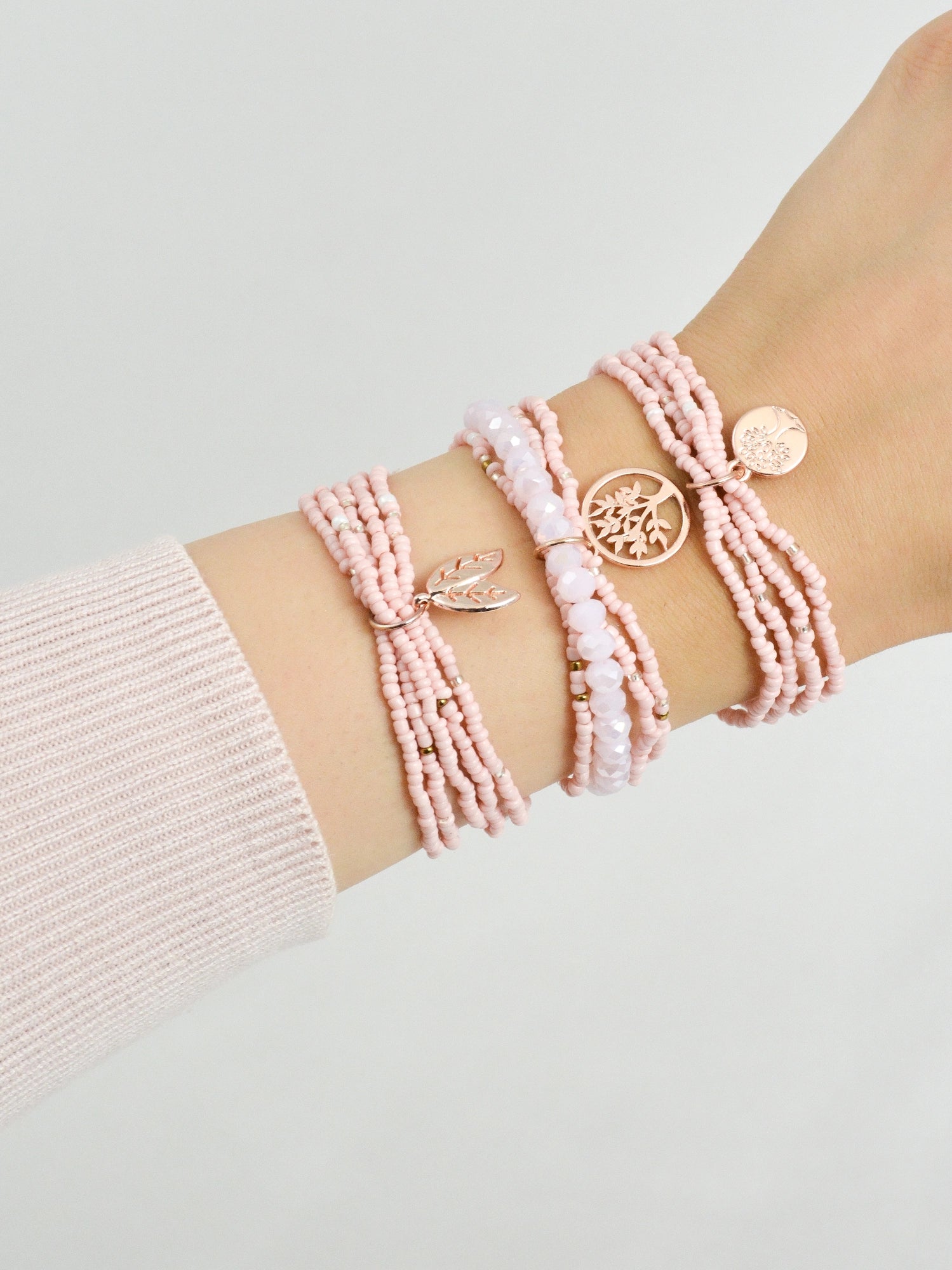 3‑teiliges Armband Set Rosa Fantasy getragen am Handgelenk – rosa und rosegold Modeschmuck