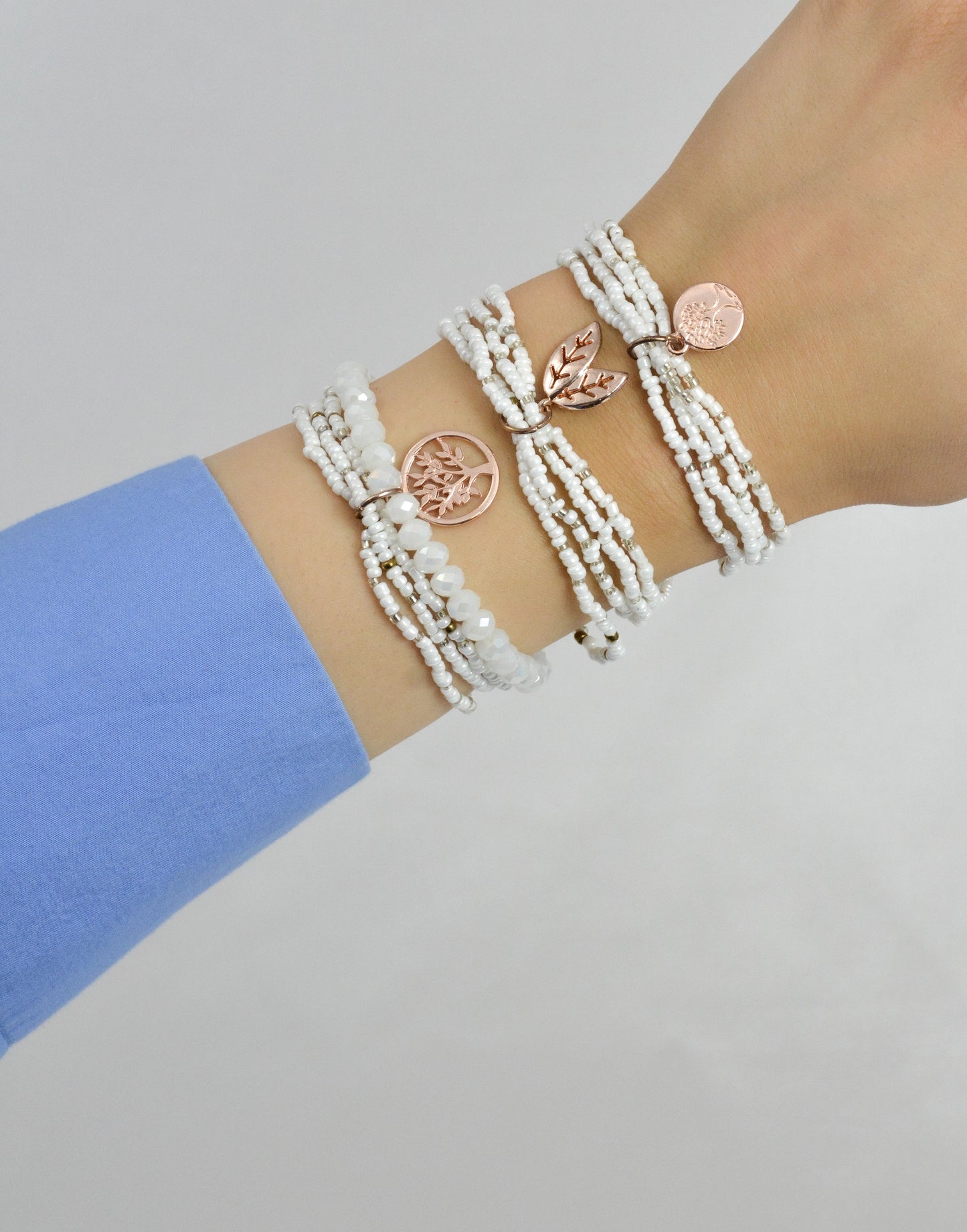 White Fantasy 3‑teiliges Armband Set am Handgelenk getragen – weißes und rosegoldfarbenes Modeschmuck Set