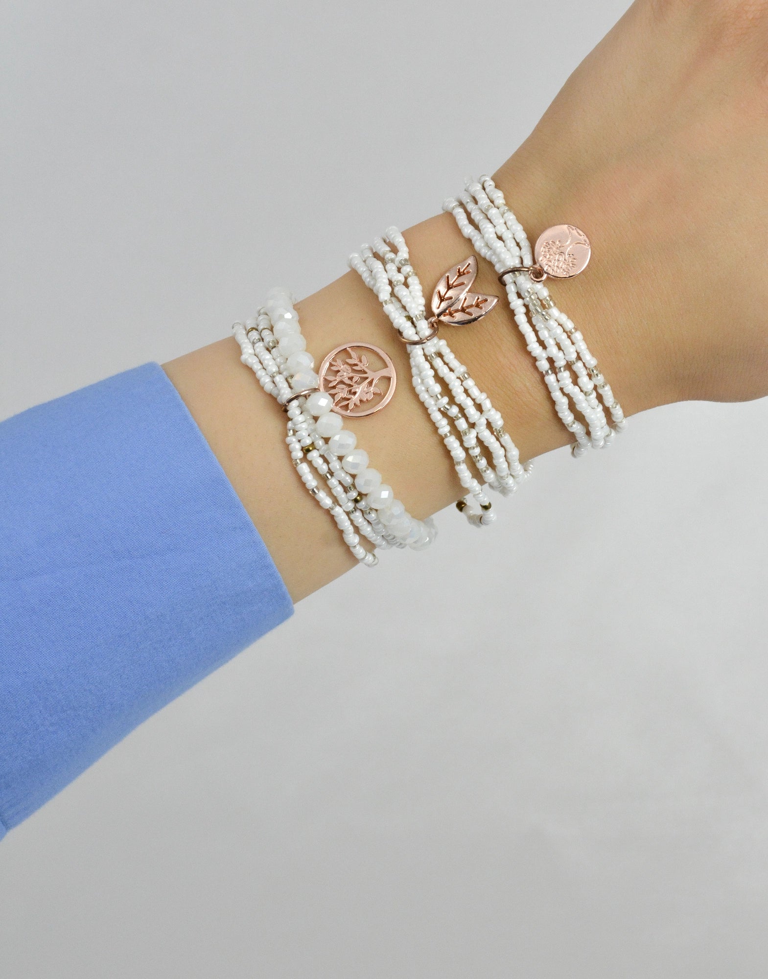 White Fantasy 3‑teiliges Armband Set am Handgelenk getragen – weißes und rosegoldfarbenes Modeschmuck Set