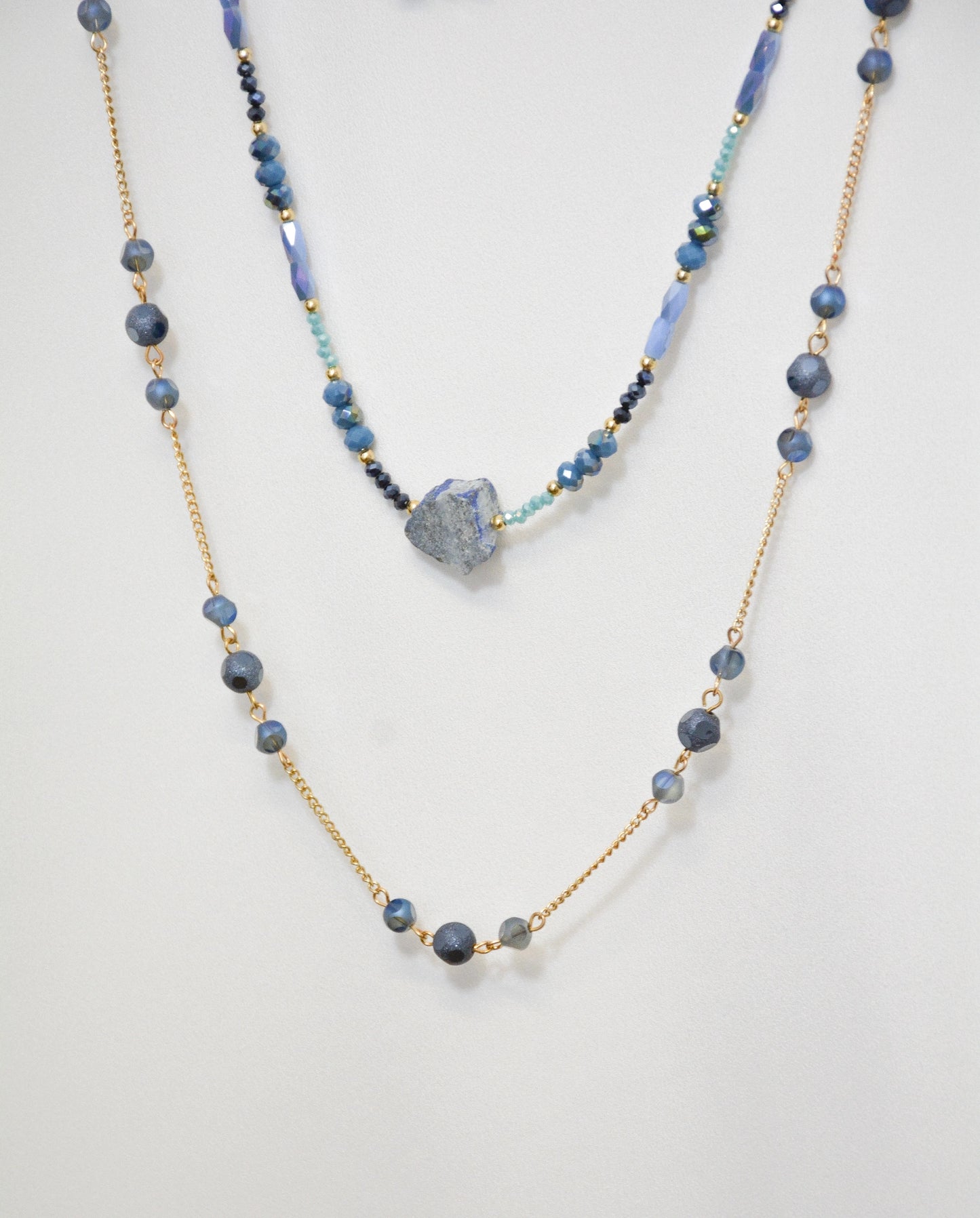 Detail der Mavi Halskette mit blauen Stein-Anhänger und goldfarbenem Metall-Design