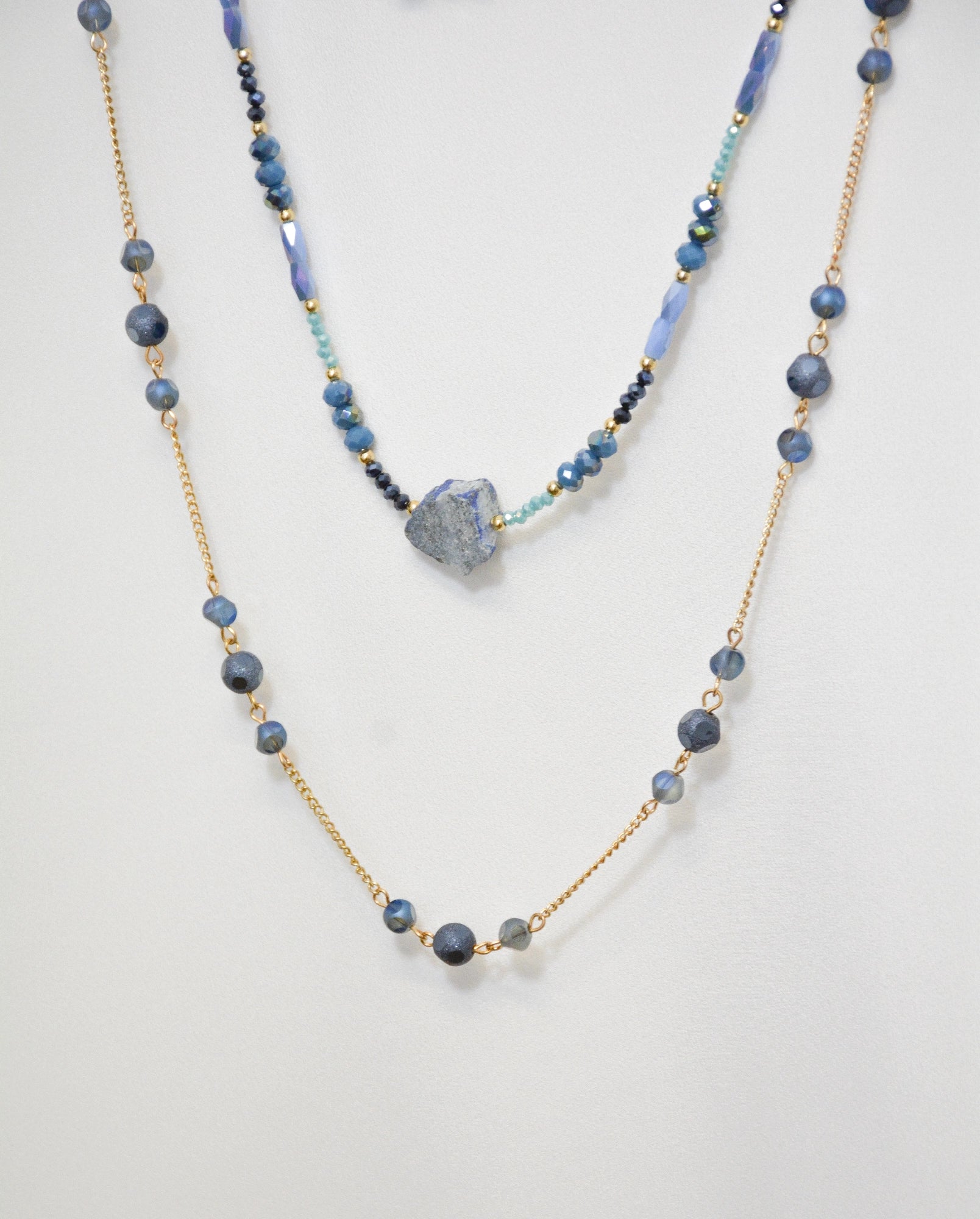 Detail der Mavi Halskette mit blauen Stein-Anhänger und goldfarbenem Metall-Design